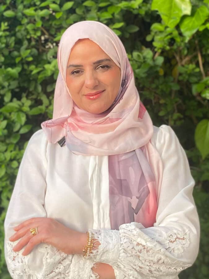 Dr Tara Rasoul, Senior Air Quality Consultant at Create Consulting Engineers, posed outdoors against green foliage background.