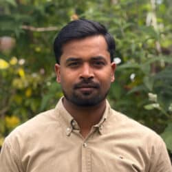 Mirza Baig, Sustainability Consultant at Create Consulting Engineers, posed outdoors against a green garden background.