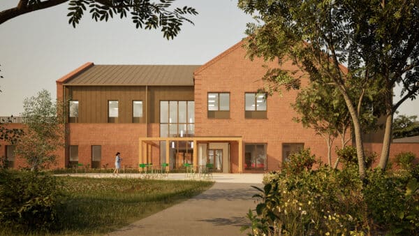 A modern two-story brick building with large windows and a metal roof, designed by Create Consulting Engineers, is surrounded by landscaping and trees, with a person walking on the path in front.
