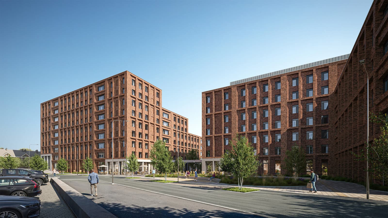 Modern red-brick apartment buildings surround a landscaped courtyard with trees, walkways, and people on a clear day. Cars are parked along the street in the foreground.