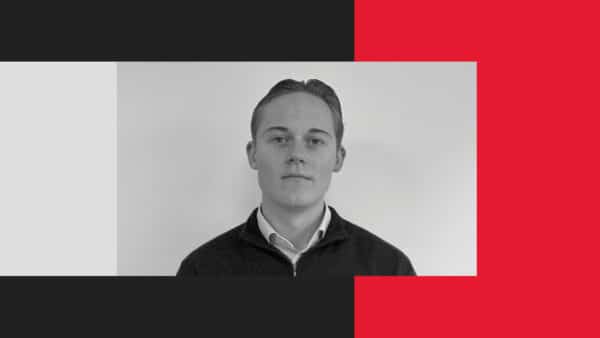 A young man with short, neatly styled hair and a collared shirt stands against a plain white background, framed by geometric blocks of black, white, and red.
