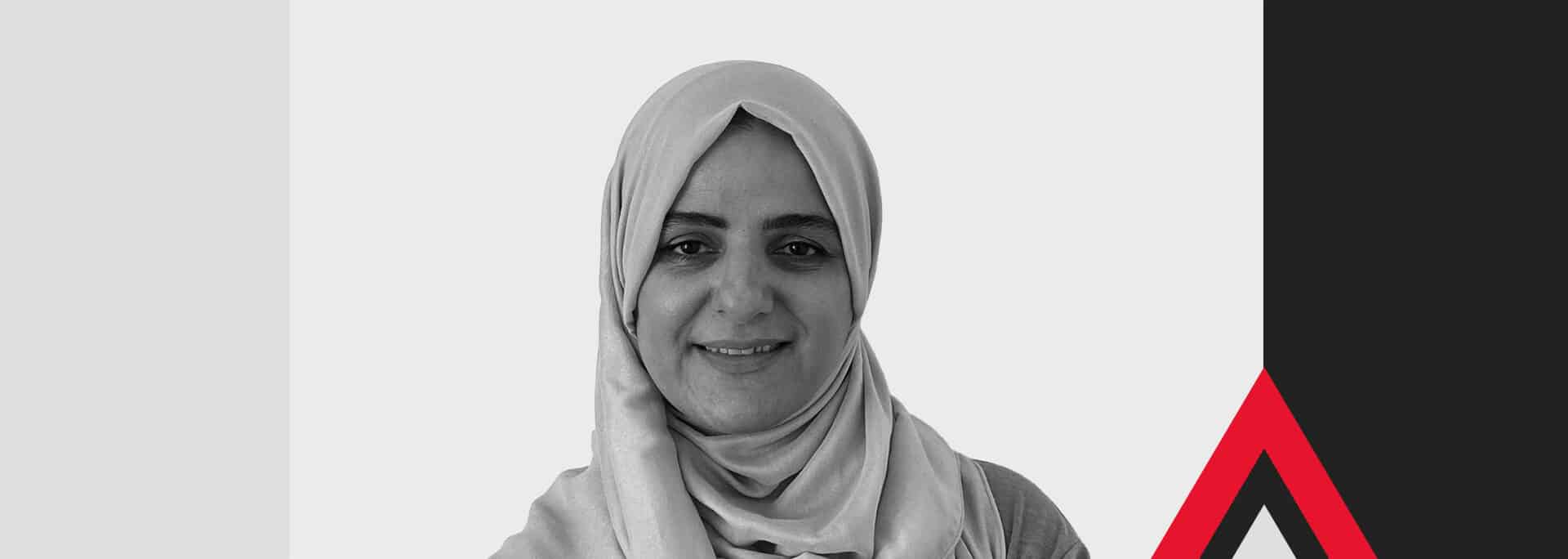 A woman wearing a light-colored hijab smiles at the camera. The background features geometric shapes in blue, black, white, and red.
