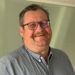 Simon Wheeler, consulting engineer at Create Consulting Engineers, wearing glasses and checkered shirt, smiling at camera