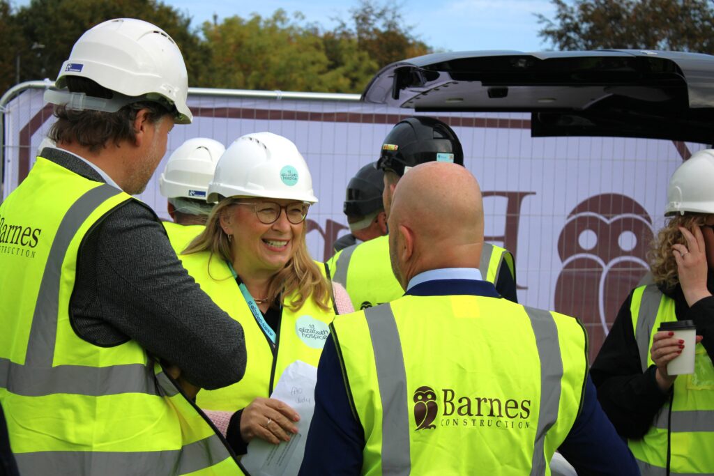 Ground breaking ceremony for St Elizabeth Hospice in Gorleston with construction team members wearing hard hats and high-visibility vests.